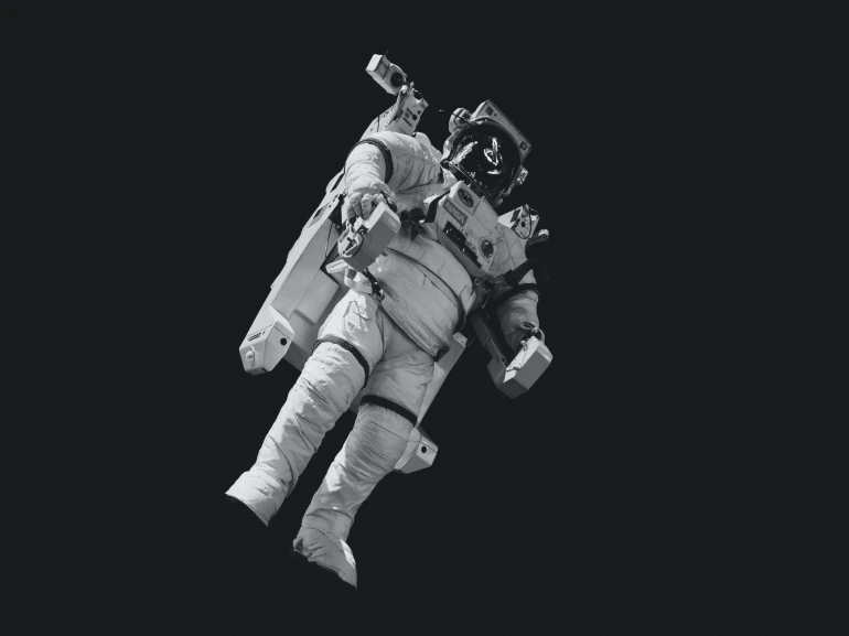 Astronaut in white suit in greyscale photo